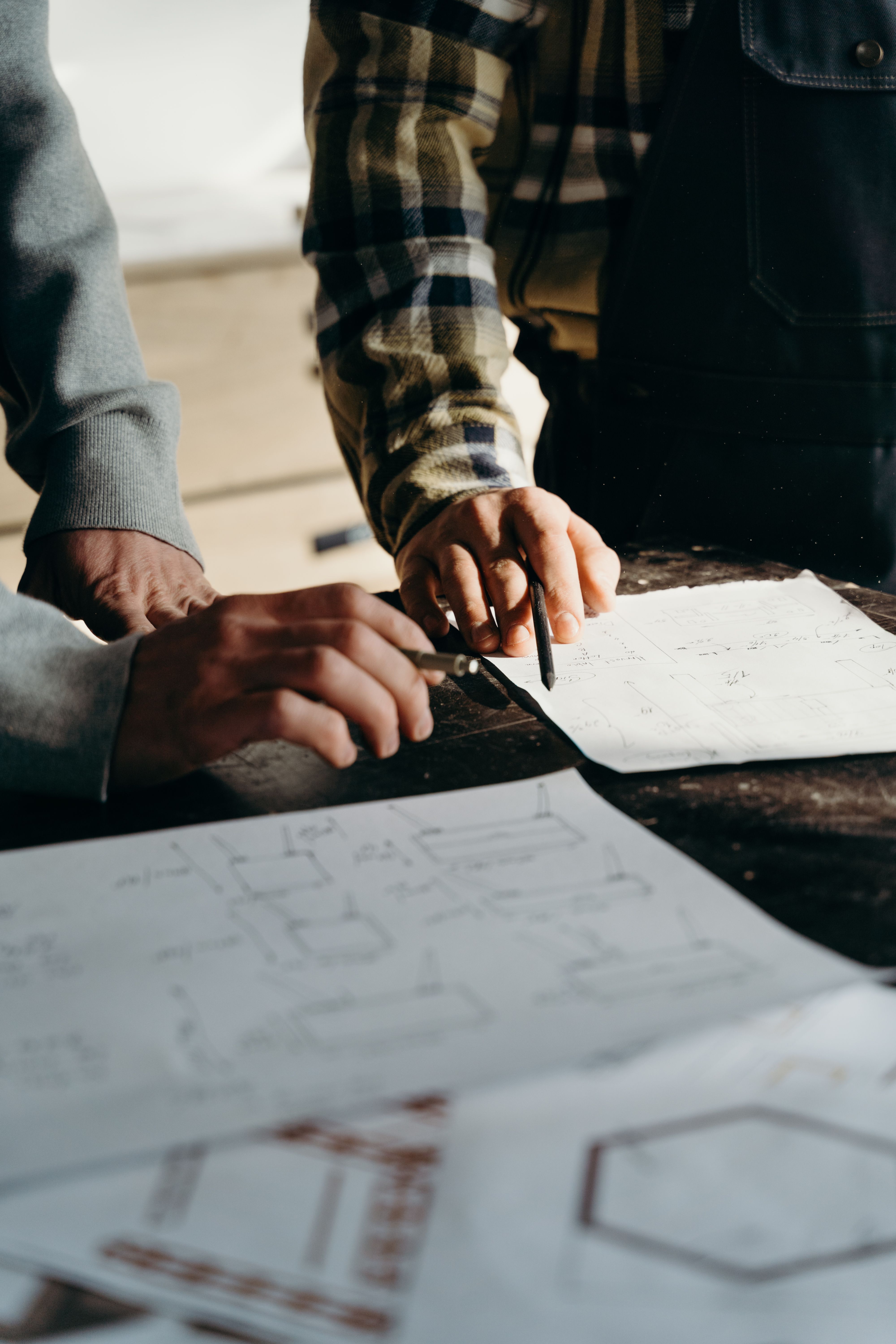 Two people discussing design drawings around a table